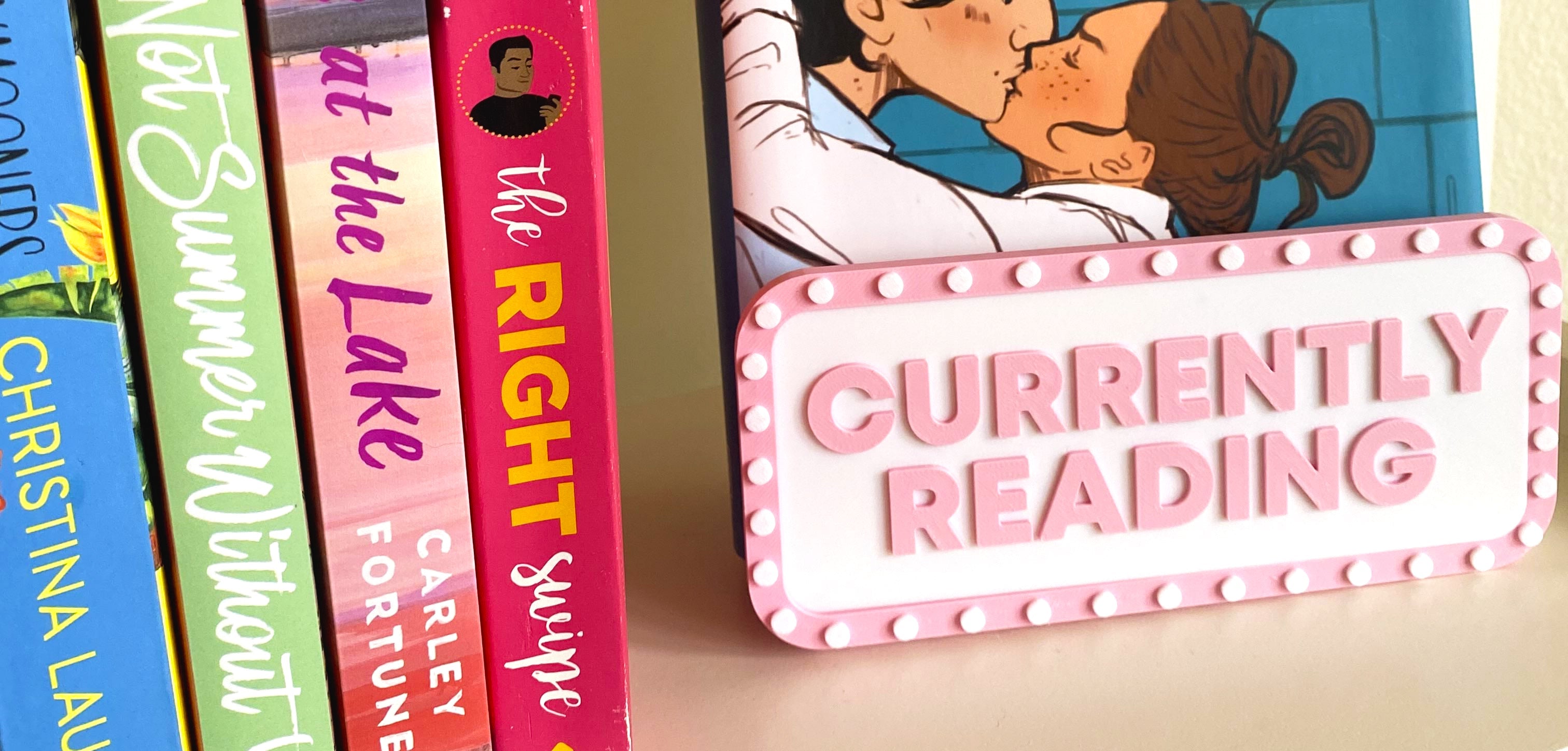 Currently Reading 3D printed book display sign on a bookshelf with romance novels